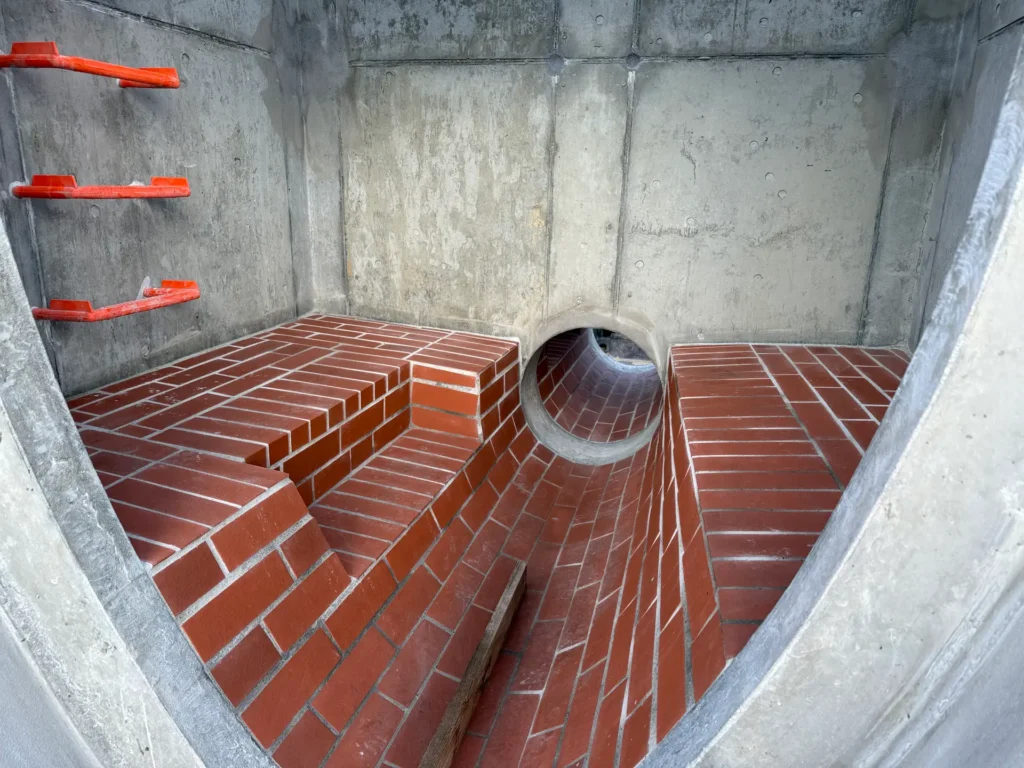 Neu angelegter Abwasserkanal, mit Pflastersteinen