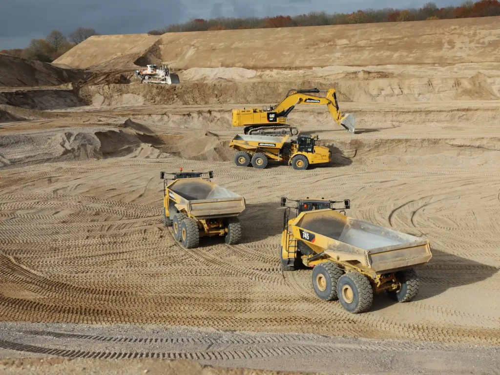 Baustelle aus der Ferne, 2 Kipplaster und ein Bagger